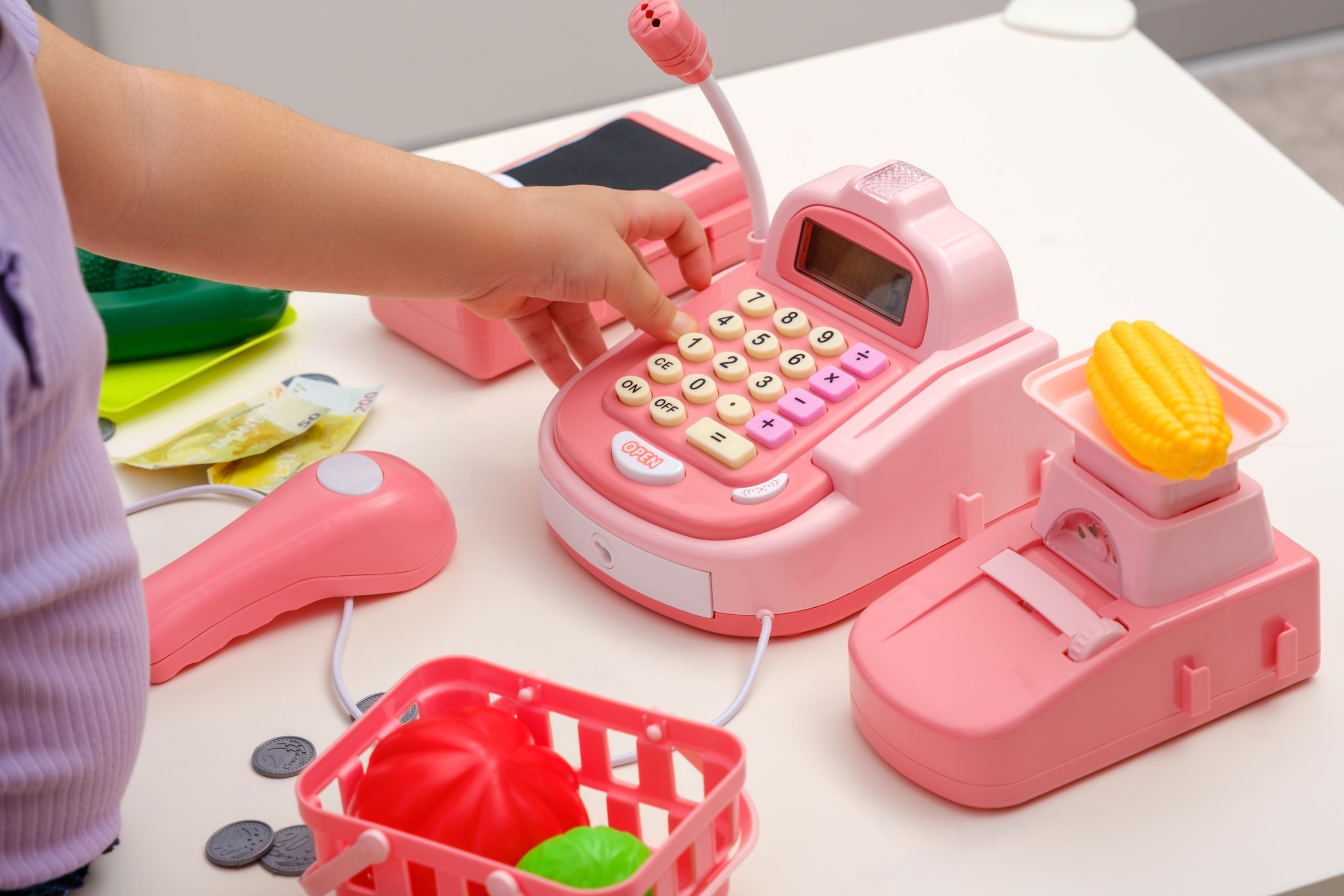 Closeup,Children's,Hands,With,Toy,Plastic,Cash,Register,,Scales,,Plastic